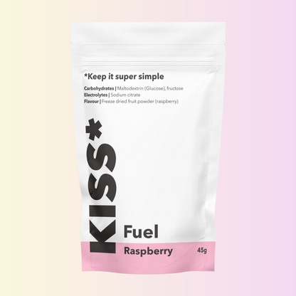 KISS Sports Fuel 45g pouch in Raspberry flavour, with product label showing ingredients: maltodextrin (glucose), fructose, sodium citrate and freeze dried raspberry powder. The pouch has a white background with a pink base and is set against a soft pastel gradient backdrop.